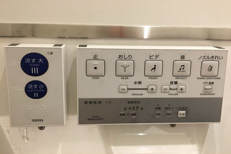 Real TOTO Washlet control panel with stop, rear, front, privacy and nozzle-cleaning buttons, and a separate flush panel